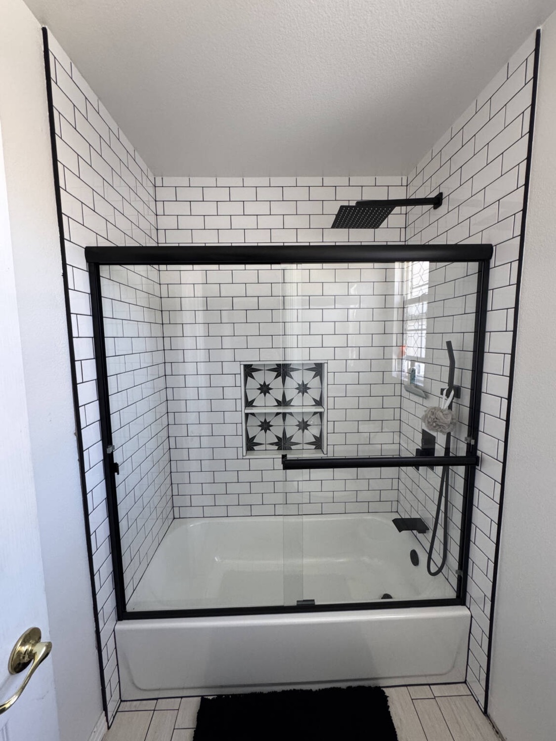 Bathroom after — subway-tile tub and glass shower